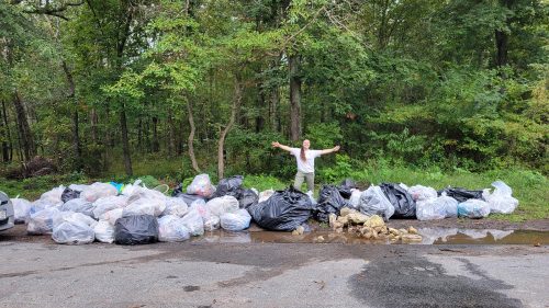 CU Maurice River intern Amy Hemple poses behind a CU crew’s trash hunt bounty. Photo: Kimberly Spiegel