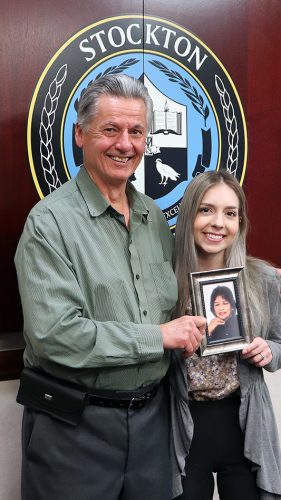 Kaganzev with Victoria DiCicco, one of the scholarship’s recipients. DiCicco is graduating this spring with her master’s degree in Communication Disorders. They are both holding a photo of Seeta Voorakkara, the speech therapist the scholarship is named for and who worked to help him with his stutter.